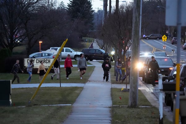 Students walk to a bus as they leave the shelter following a shooting at the Abundant Life Christian School, Monday, Dec. 16, 2024. (AP Photo/Morry Gash)