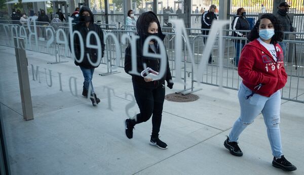 People make their way into Mercedes-Benz Stadium on Thursday morning, April 22, 2021 for COVID -19 vaccinations. The site is open this week for walk-up vaccinations without appointment. (Ben Gray for The Atlanta Journal-Constitution)