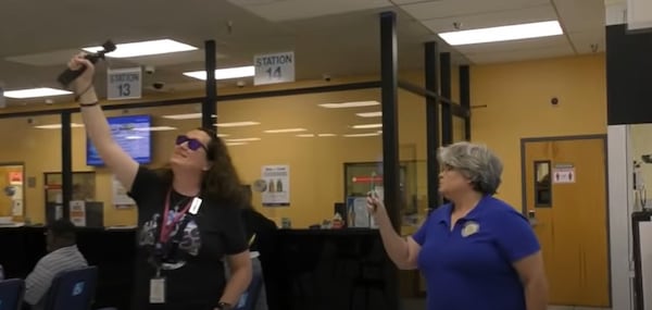 YouTuber Lana Patrick (left) and DeKalb County Magistrate Judge Shannon McNeal film each other inside the county's central tag office.