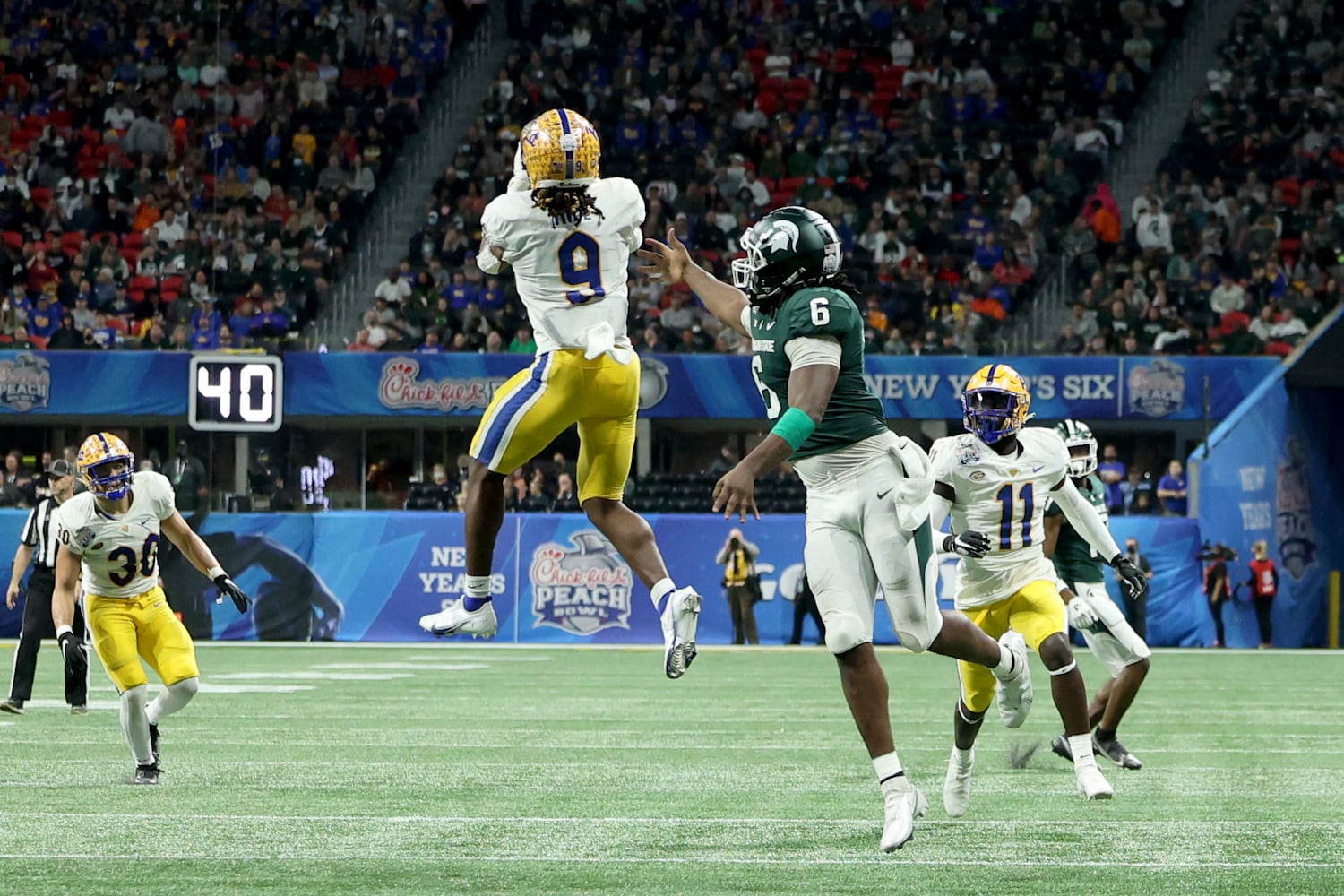 Pittsburgh Panthers defensive back Brandon Hill (9) intercepts a pass intended for Michigan State Spartans tight end Maliq Carr (6) during the first half of the Chick-fil-A Peach Bowl at Mercedes-Benz Stadium in Atlanta, Thursday, December 30, 2021. JASON GETZ FOR THE ATLANTA JOURNAL-CONSTITUTION