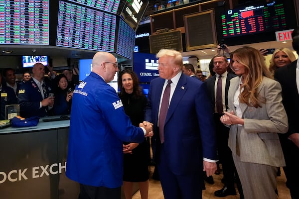 President-elect Donald Trump, with Lynn Martin, President NYSE, center, and Melania Trump, right, is greeted by trader Peter Giacchi, as he walks the floor of the New York Stock Exchange, Thursday, Dec. 12, 2024, in New York. (AP Photo/Alex Brandon)