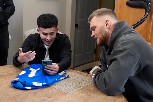 Detroit Lions' Aidan Hutchinson listens as Jacob Rinehart video calls with Lions' receiver Amon-Ra St. Brown, Thursday, Nov. 14, 2024, in Chesterfield Township, Mich. (AP Photo/Carlos Osorio)