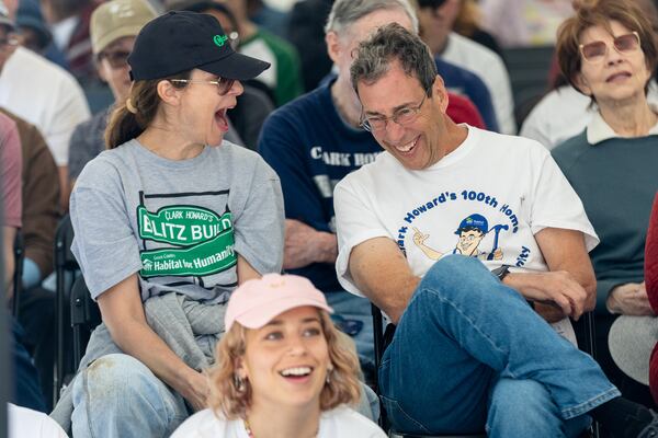 Lane and Clark Howard listen to the speakers during the Atlanta Habitat for Humanity dedication ceremony of the 98, 99, and 100th Howard's sponsored homes in Atlanta on Saturday, April 13, 2024. (Steve Schaefer/ steve.schaefer@ajc.com)