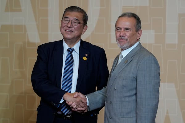 Peru's Foreign Affairs Minister Elmer Schialer, right, welcomes Japan's Prime Minister Shigeru Ishiba to the Asia-Pacific Economic Cooperation (APEC) leaders meeting in Lima, Peru, Saturday, Nov. 16, 2024. (AP Photo/Fernando Vergara)