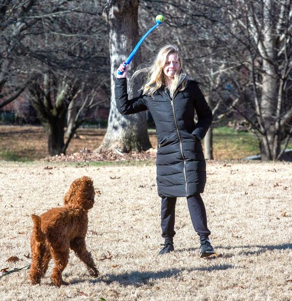 Carter Tindall tries to stay warm while exercising her dog Frannie in Piedmont Park, Christmas morning on December 25, 2020. STEVE SCHAEFER FOR THE ATLANTA JOURNAL-CONSTITUTION