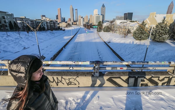 Megan Chen crosses the Jackson Street bridge above a deserted, snow-covered Freedom Parkway below on Wednesday, Jan. 17, 2018, in Atlanta. JOHN SPINK/JSPINK@AJC.COM