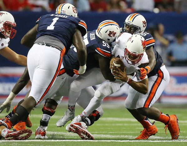  090515 ATLANTA: Louisville quarterback Reggie Bonnafon is sacked by Auburn defenders Carl Lawson (center) and Dontavius Russell (right) during the second quarter in the Chick-fil-A Kickoff Game on Saturday, Sept. 5, 2015, in Atlanta. Curtis Compton / ccompton@ajc.com