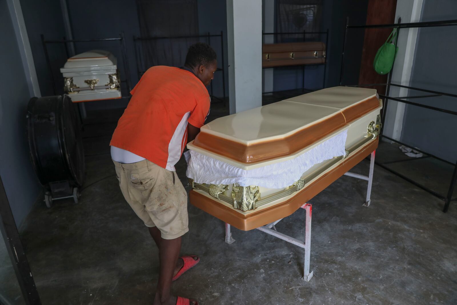 Morgue workers move an empty coffin in Pont-Sonde, Haiti, Tuesday, Oct. 8, 2024, days after a deadly gang attack on the town. (AP Photo/Odelyn Joseph)