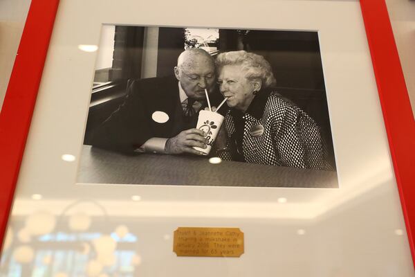 A photograph from 2006 of Truett and Jeannette Cathy sharing a milkshake hangs on a wall inside the newly renovated Dwarf House, the first of Truett Cathey’s restaurants. Curtis Compton / Curtis.Compton@ajc.com”`