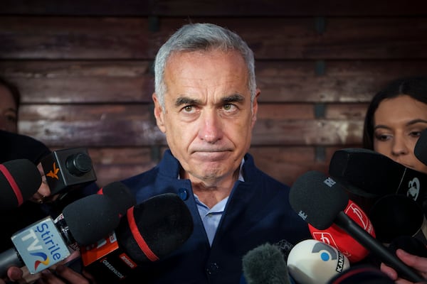 FILE - Calin Georgescu, running as an independent candidate for president touches his face while speaking to media, in Izvorani, Romania, Tuesday, Nov. 26, 2024, after making it to the Dec. 8 election runoff. (AP Photo/Vadim Ghirda, File)