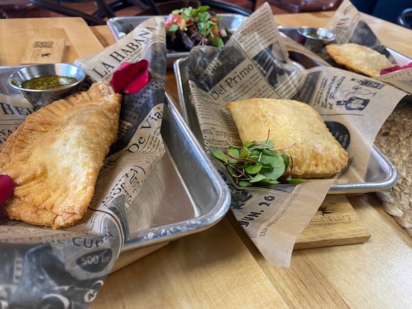 An assortment of fried handheld appetizers from Belle & Lily's includes (from left) beef empanada, Jamaican patty and chicken empanada. Ligaya Figueras/ligaya.figueras@ajc.com