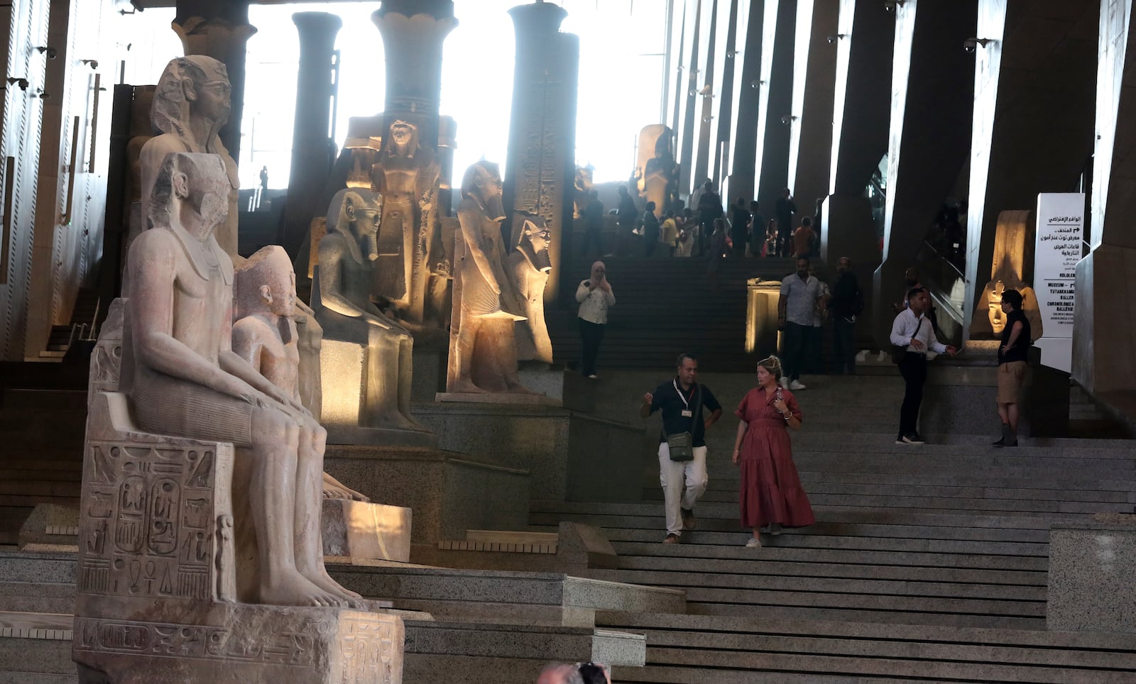 Visitors walk past ancient Egyptian colossal statues along the Grand Staircase at the Grand Egyptian Museum in Giza, Egypt, Tuesday, Oct.15, 2024. (AP Photo/Khaled Elfiqi)