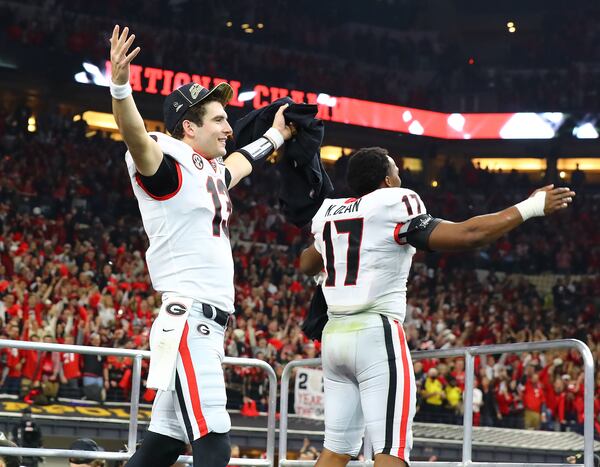 Stetson Bennett and Nakobe Dean take in the cheers of the fans as they take the stage to celebrate winning the College Football Playoff Championship game over Alabama on Monday, Jan. 10, 2022, in Indianapolis.  “Curtis Compton / Curtis.Compton@ajc.com”`