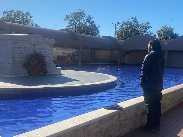 Visitor reflects at Martin Luther King Jr.'s tomb on MLK Day 2025.