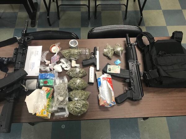 Deputies seized guns, drugs and a bulletproof vest.