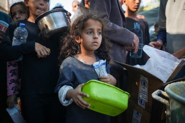 A Palestinian little girl queues for food in Deir al-Balah, Gaza Strip, Monday, Nov. 18, 2024. (AP Photo/Abdel Kareem Hana)