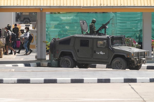 Thai soldiers provide security for the transfer of Indonesia nationals who had worked at scam centers in eastern Myanmar, on their arrival at Thailand's Mae Sot, Tak province before being sent back to Indonesia on Thursday, Feb. 27, 2025. (AP Photo/Sakchai Lalit)