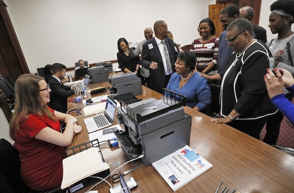 Stacy Abrams, joined by her parents, Rev. Robert Abrams and Rev. Carolyn Abrams, and supporters as she qualifies for the 2018 gubernatorial race. Abrams was co-owner of a company that contracted with the state through two related non-profit corporations while she was a legislator. BOB ANDRES /BANDRES@AJC.COM