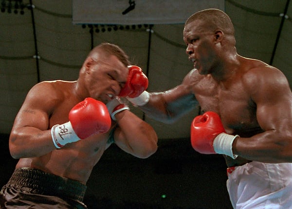 James "Buster" Douglas, right, hits Mike Tyson with a hard right in the face during their world heavyweight title bout at the Tokyo Dome on Feb. 11, 1990. Douglas is marking the 30th anniversary of his upset boxing victory over Tyson with a campaign aimed to inspire others who face long odds.