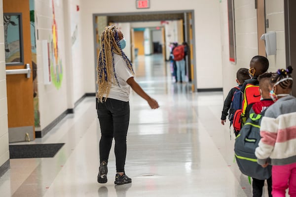 10/5/2020 - Atlanta, Georgia - Clarkdale Elementary School kindergarten paraprofessional Destani Rutherford leads a group of students to the buses after school is dismissed in Austell, Monday, October 5, 2020. Cobb County schools, the stateÕs second largest district with about 112,000 students, will begin the first phase of its reopening plan on Monday, Oct. 5. The district will reopen classes to students in pre-kindergarten through fifth grade and kindergarten through 12th grade special education students. (Alyssa Pointer / Alyssa.Pointer@ajc.com)