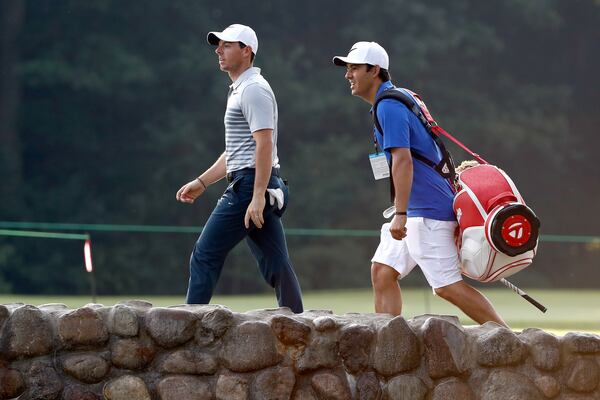 Rory McIlroy of Northern Ireland speaks to his new caddie Harry Diamond during a preview day of the World Golf Championships.