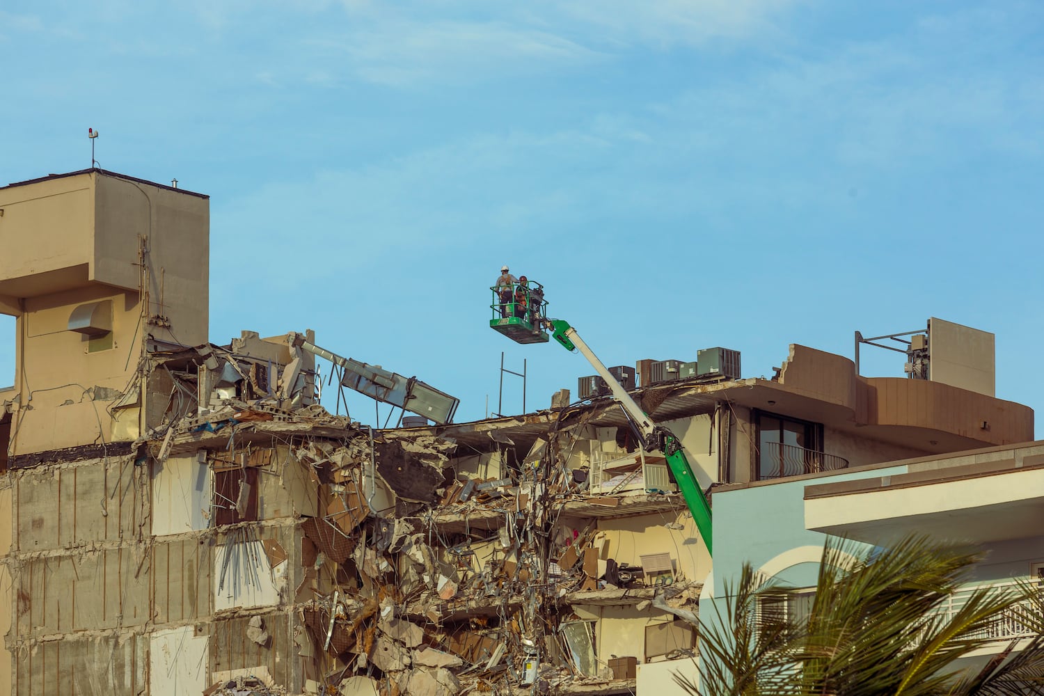 Rescue workers survey the partially collapsed 12-story Champlain Towers South condo building in Surfside, Fla., Friday morning June 25, 2021. (Saul Martinez/The New York Times)