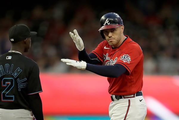 Atlanta Braves' Freddie Freeman, right, celebrates beside Miami Marlins' Jazz Chisholm Jr. (2) after hitting a double off Marlins pitcher Trevor Rogers in the first inning of a baseball game Friday, Sept. 10, 2021, in Atlanta. (AP Photo/Ben Margot)