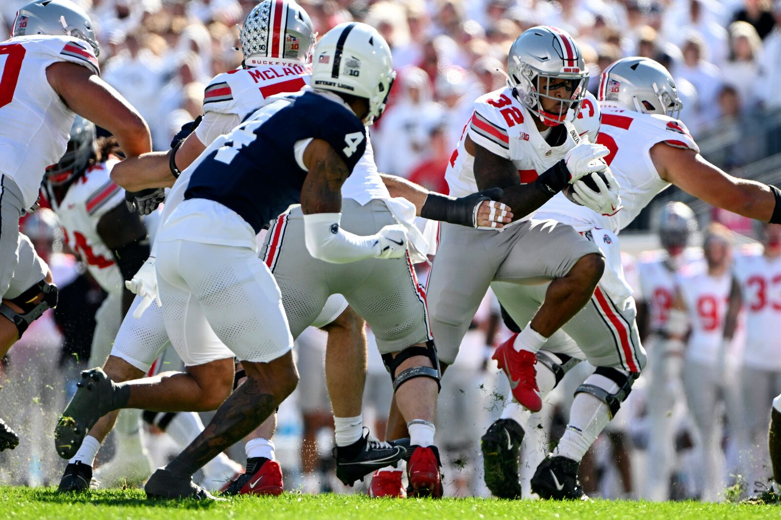 Ohio State running back TreVeyon Henderson (32) looks to elude Penn State cornerback A.J. Harris (4) during the second quarter of an NCAA college football game, Saturday, Nov. 2, 2024, in State College, Pa. (AP Photo/Barry Reeger)