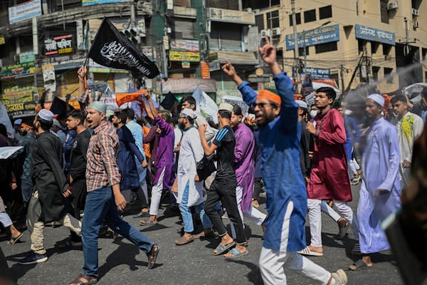 Members and supporters of the banned Islamist group Hizbut Tahrir shout slogans as they march near Baitul Mokarram Mosque in Dhaka, Bangladesh, Friday, March 7, 2025. (AP Photo/Mahmud Hossain Opu)