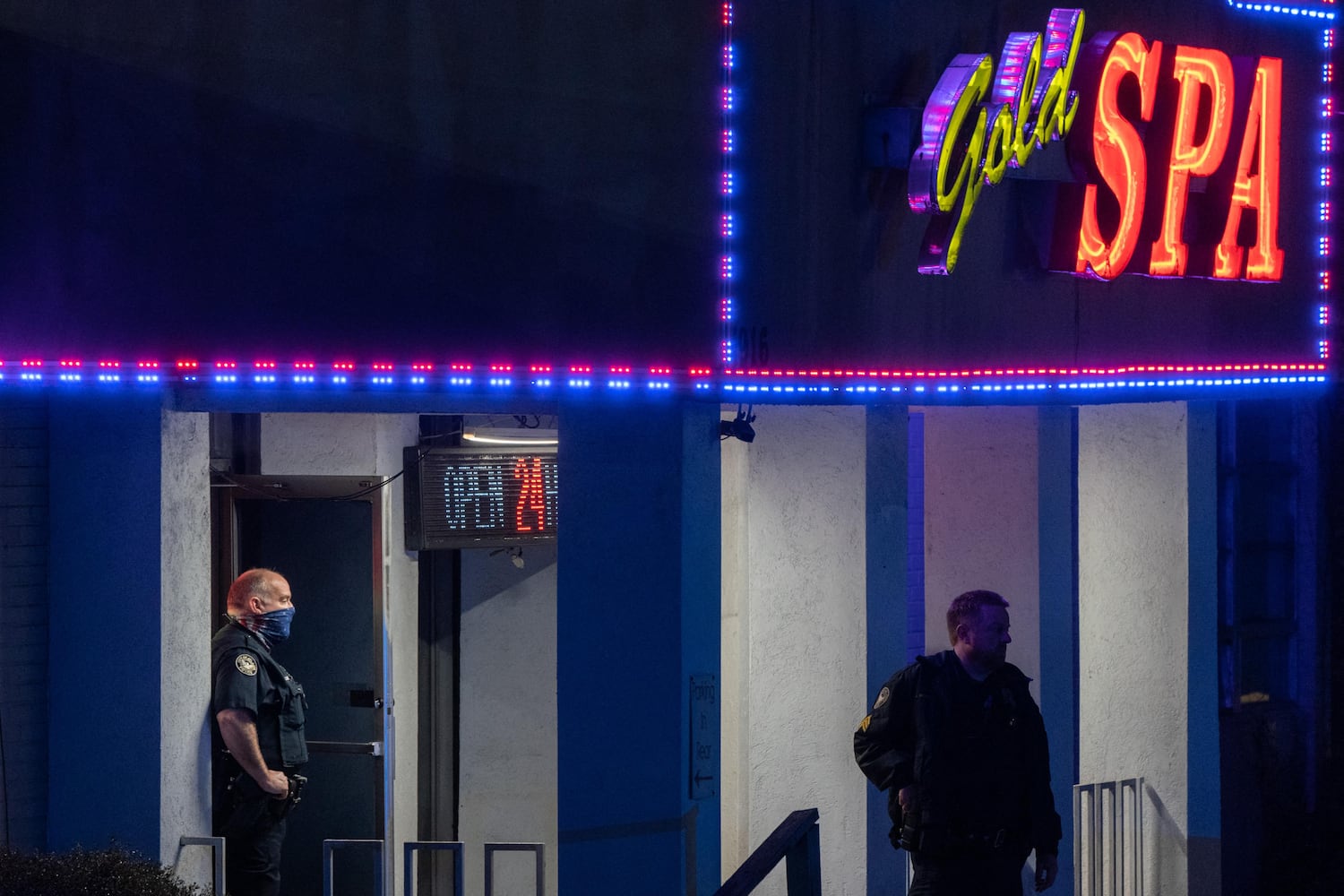 Police officers standing outside a massage parlor where three people were shot and killed Tuesday evening. ELIJAH NOUVELAGE/Getty Images