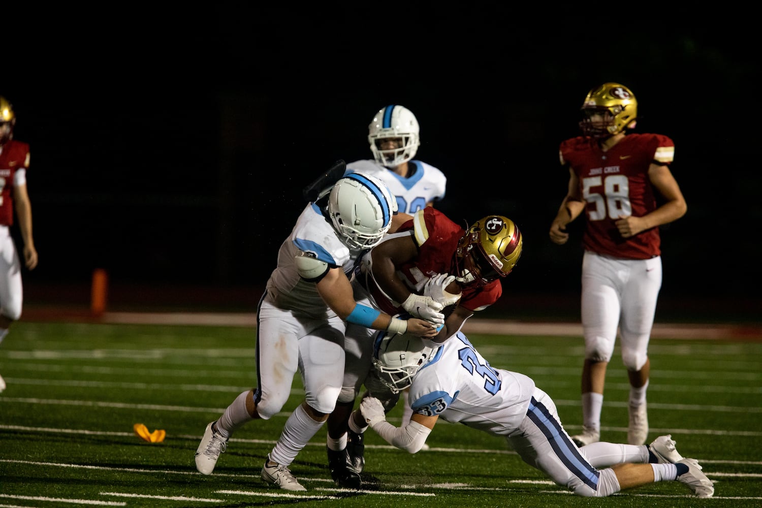 Johns Creek's Dubem Nwizugbo (22) is tackled during a GHSA high school football game between Cambridge High School and Johns Creek High School in Johns Creek, Ga. on Friday, October 15, 2021. (Photo/Jenn Finch)