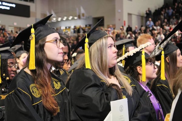 Graduates from Kennesaw State University’s College of the Arts stand for the national anthem at their commencement ceremony, held Dec. 12 in the school’s Convocation Center. (Photo Courtesy of Annie Mayne)