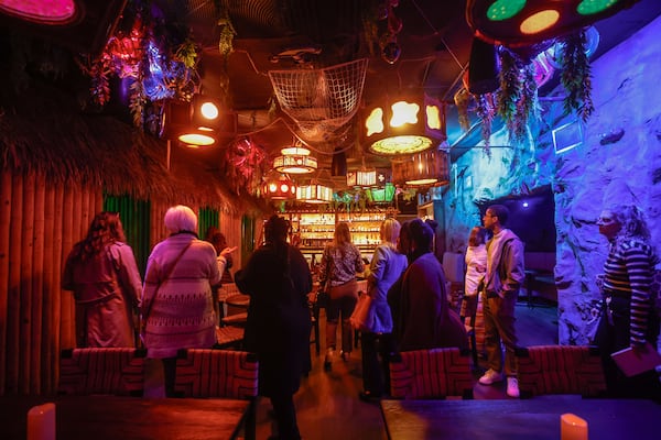 Participants stand inside Agave Bandido’s hidden speakeasy during the Rediscover Dunwoody Trolley Tour. (Natrice Miller/AJC)