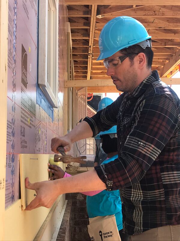 Jonathan Scott working on siding at Krushetta Holt's Habitat home in Atlanta Thursday, March 28, 2019.