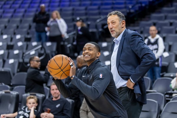 San Antonio Spurs guard De'Aaron Fox, left, warms up as former Sacramento Kings player Vlade Divac, right, looks on before an NBA basketball game against the Kings, Friday, March 7, 2025, in Sacramento, Calif. (AP Photo/Sara Nevis)