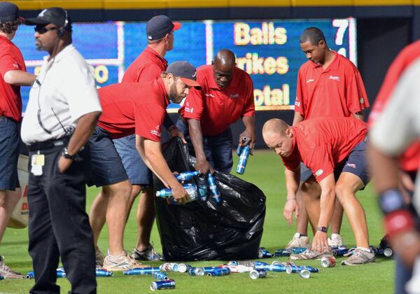 Braves ground crew members clean up the trash angry fans threw on the field during the 2012 National League wild card game.