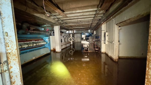 In the basement of the long-shuttered Macon Hilton, standing water has pooled in what appears to be an abandoned laundry room. (Joe Kovac Jr. / AJC)