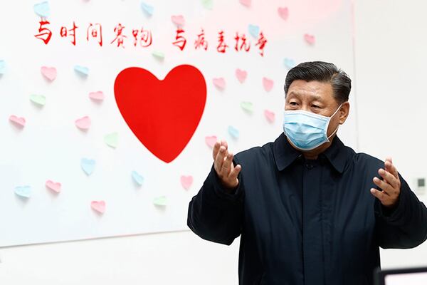 Chinese President Xi Jinping gestures near a heart shape sign and the slogan "Race against time, Fight the Virus" during an inspection of the center for disease control and prevention of Chaoyang District in Beijing.