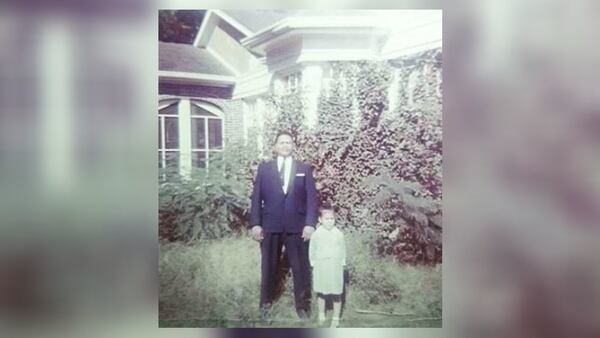 Atlanta police Officer Claude Mundy stands outside his home with his youngest daughter, Marilyn. (Credit: Family photo)