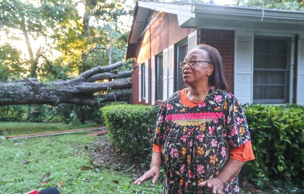 Virginia White stands in front of her home Tuesday after it was damaged by a fallen tree during strong storms the day before.