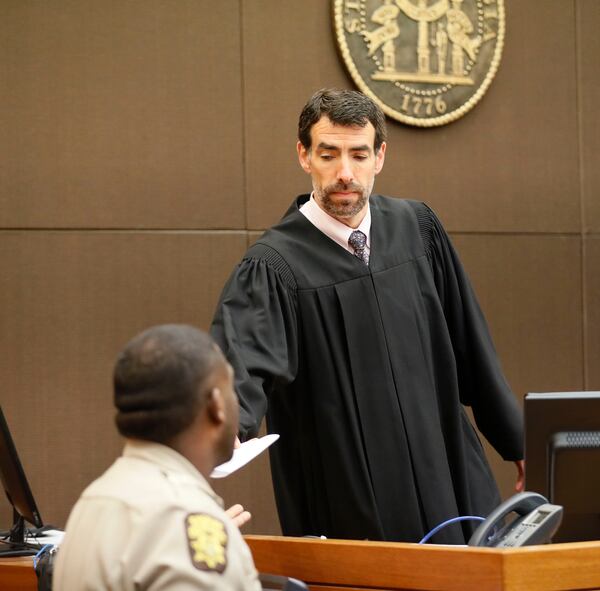 4/23/18 - Atlanta - After reading the verdict,  Fulton County Chief Judge Robert McBurney hands it over for the jury foreman to read.  The jury found Tex McIver guilty on four of five charges on their fifth day of deliberations today at the Tex McIver murder trial at the Fulton County Courthouse.   Bob Andres bandres@ajc.com