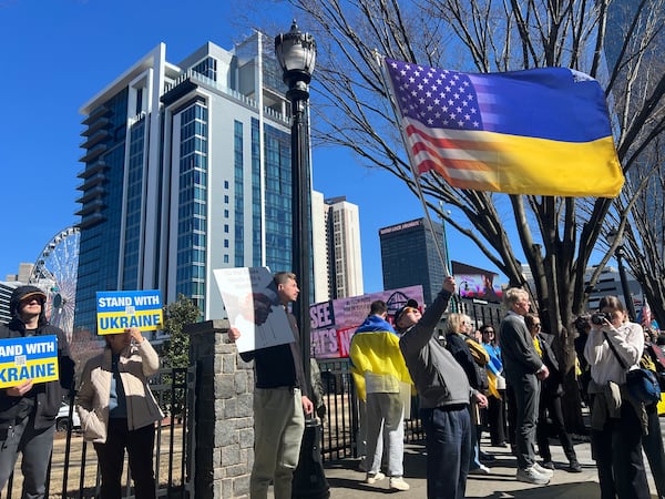 One demonstrator holds an American flag in a Ukrainian flag in the Centennial Olympic Park. (Ashley Ahn for AJC)