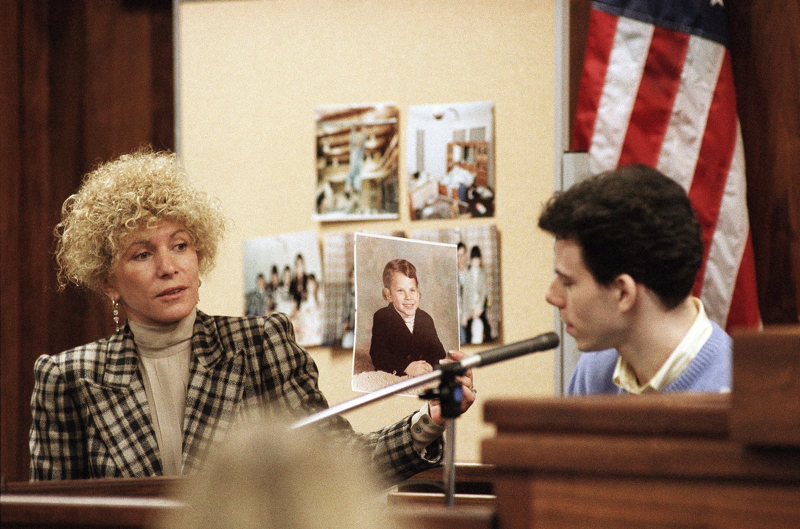 FILE - Erik Menendez listens to defense attorney Leslie Abramson while she holds a photograph of him as a young boy during testimony in Los Angeles, Sept. 29, 1993. (AP Photo/Nick Ut, File)