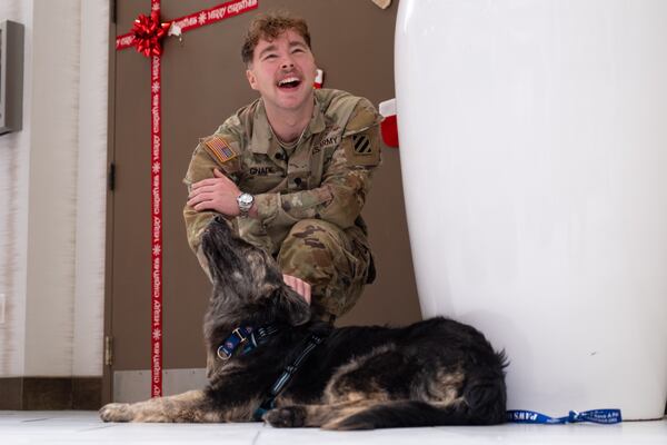 Army National Guard Spc. Landon Gnade with his dog Lepo in Atlanta on Tuesday, Dec. 17, 2024. Gnade began caring for Lepo when the dog was a puppy and Gnade was deployed to Kosovo. He was able to adopt the dog on his return to Dallas with the help of the group Paws of War. Ben Gray for the Atlanta Journal-Constitution