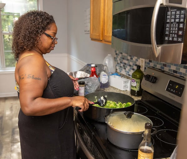 Ebon Sledge prepares dinner for her eight children in their new rental home in metro Atlanta. PHIL SKINNER FOR THE ATLANTA JOURNAL-CONSTITUTION