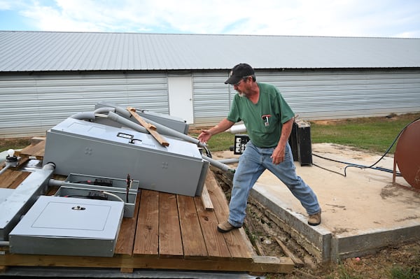 Doug Harper shows damaged generator pieces caused by Hurricane Helene outside chicken houses, Tuesday, October 1, 2024, in Nashville, Ga. Harper lost his chickens after his property lost power. (Hyosub Shin / AJC)