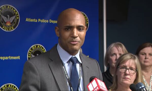 Family members of Thomas Arnold look on from behind as Lt. Ralph Woolfolk talks to reporters Wednesday night.