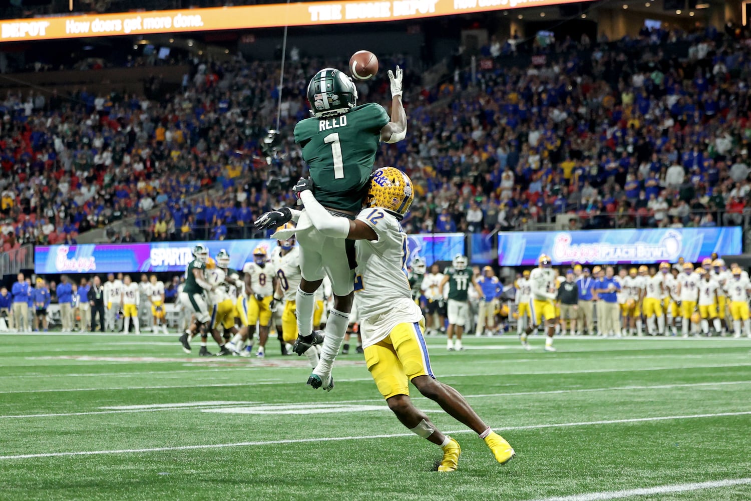 Michigan State Spartans wide receiver Jayden Reed (1) catches the go-ahead touchdown against Pittsburgh Panthers defensive back M.J. Devonshire (12) in the fourth quarter of the Chick-fil-A Peach Bowl at Mercedes-Benz Stadium in Atlanta, Thursday, December 30, 2021. JASON GETZ FOR THE ATLANTA JOURNAL-CONSTITUTION