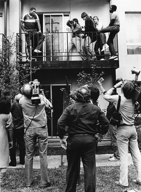 Herschel Walker stands on his back patio with reporters and photographers trying to interview him. Steve Deal / AJC file photo