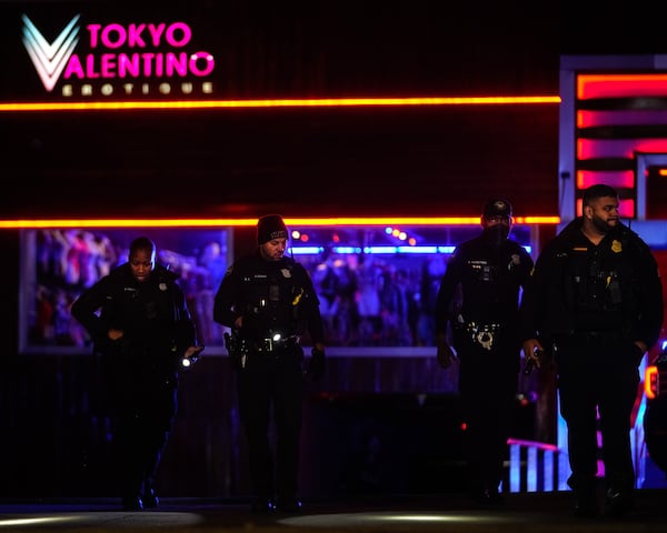 Atlanta officers search the parking lot of Tokyo Valentino on Cheshire Bridge Road for shell casings. 